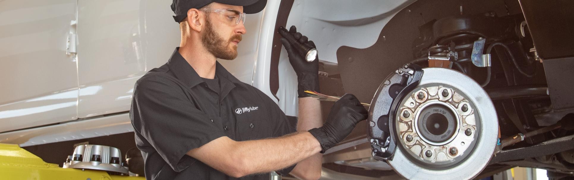 jiffy lube employee inspecting a vehicle's anti lock brake