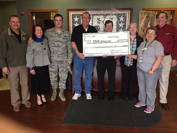 Employees holding large USO Check