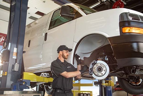 Jiffy Lube employee inspecting fleet vehicle brakes