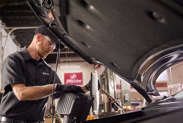 Jiffy Lube employee inspecting under the hood