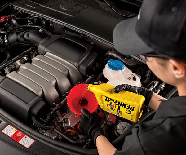 Woman pouring Pennzoil for oil change