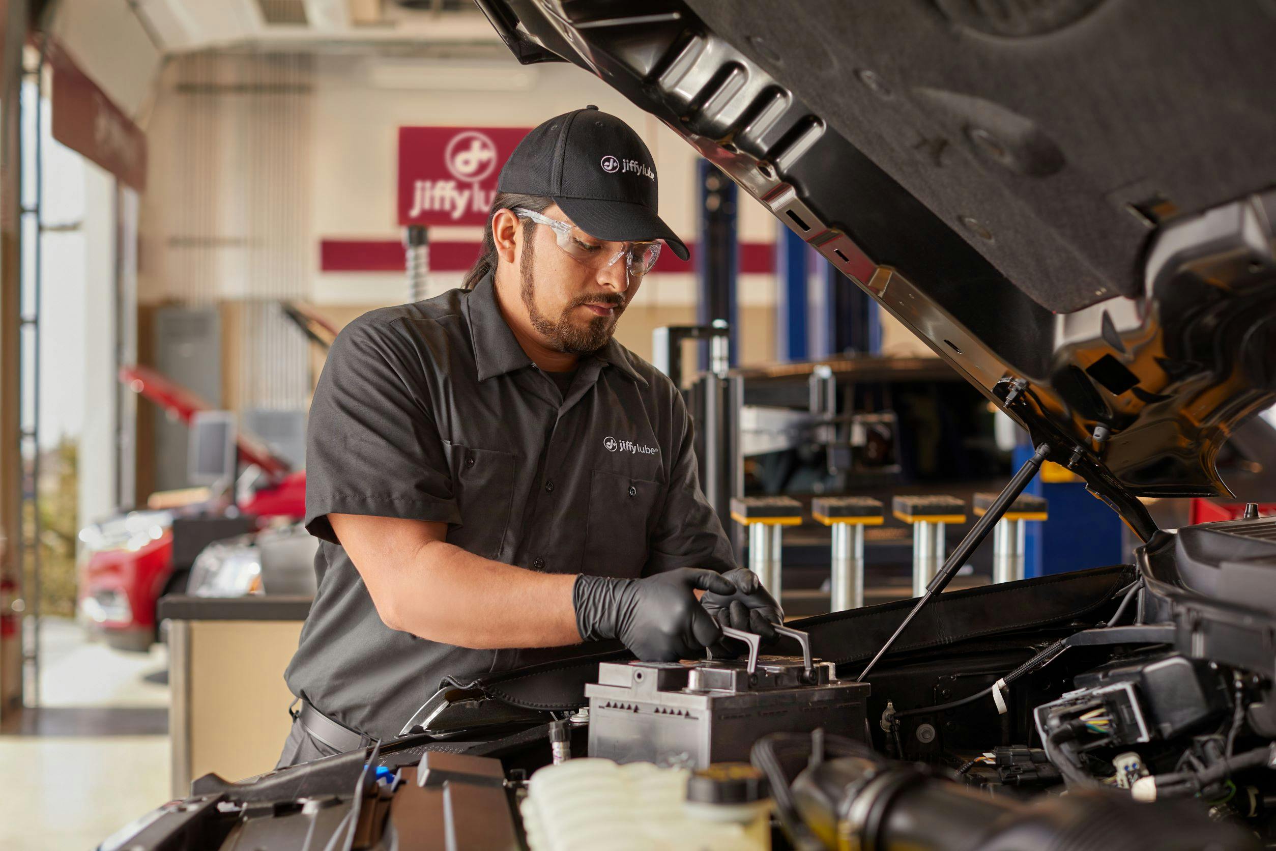 jiffy lube employee replacing a car battery