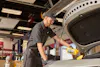 Jiffy lube technician performing routine maintenance by changing a vehicle