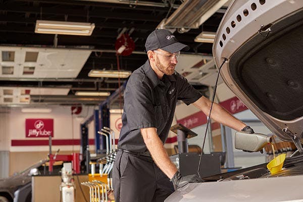 a jiffy lube trained technician performing an oil change