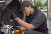 Service member using a flashlight to check a car