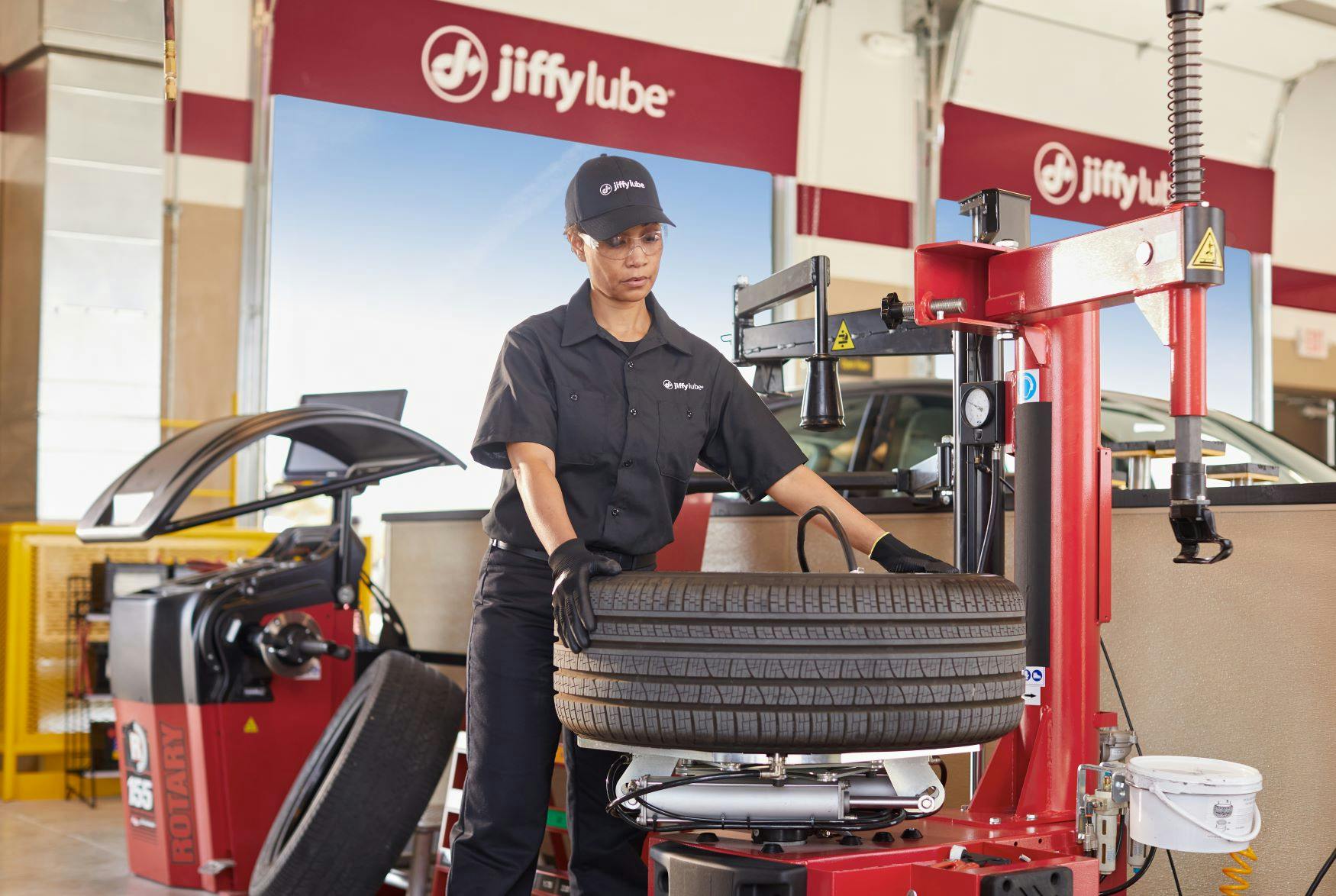 Jiffy Lube technician using a machine to balance a vehicle's tire during a tire inspection and/or replacement service