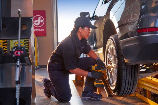 A Jiffy Lube technician changing a tire