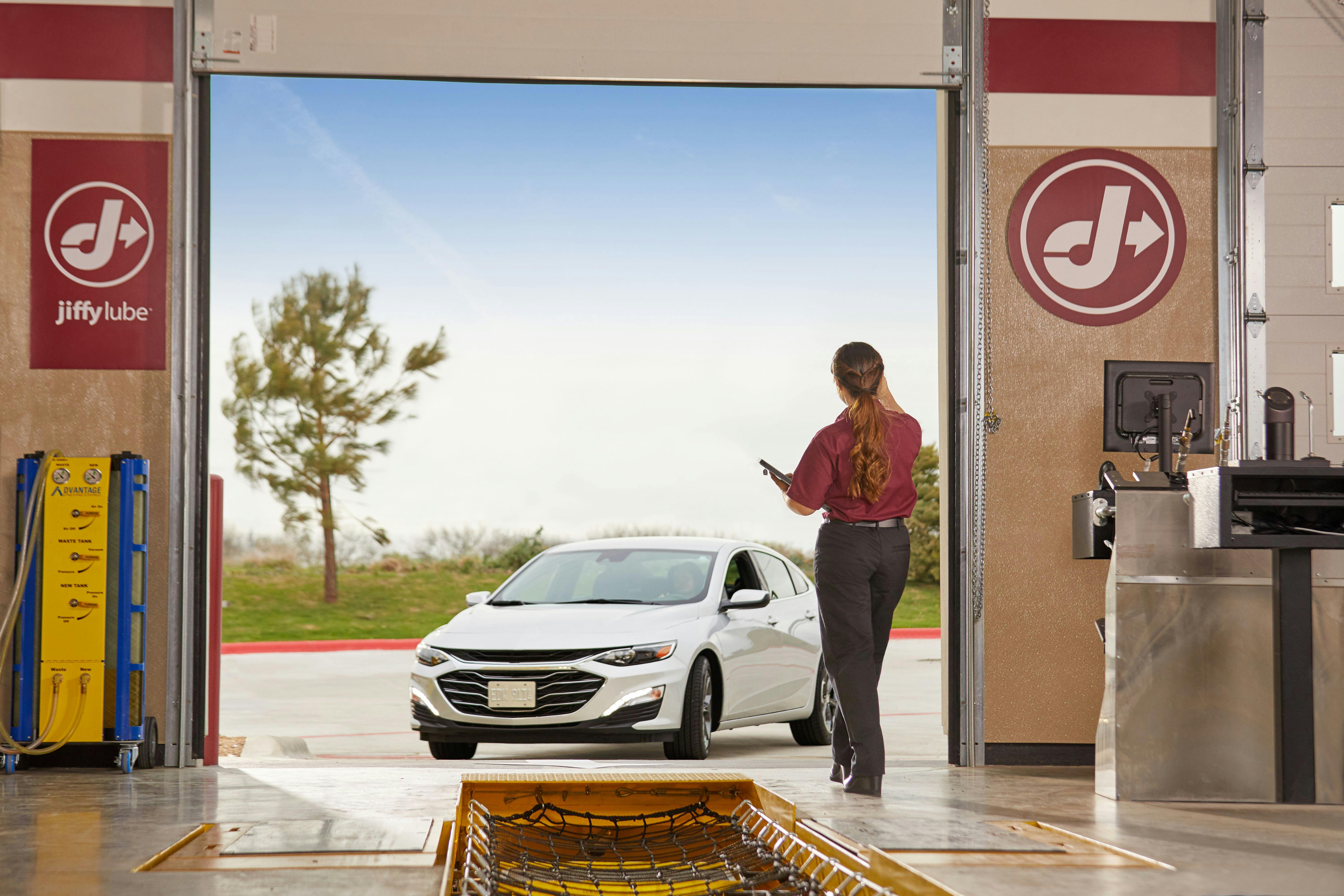 Jiffy Lube employee waiving customer into the bay