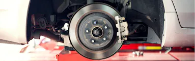 Close-up of a car’s exposed brake rotor during brake service