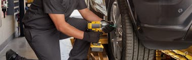 Jiffy Lube technician tightening lug nuts after servicing a vehicle's tire