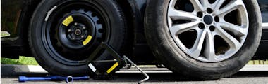 Close up of flat tire being replaced with a spare tire