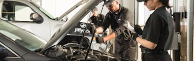 Two Jiffy Lube technicians going through a vehicle inspection checklist
