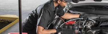 jiffy lube employee checking the transmission fluid of a vehicle