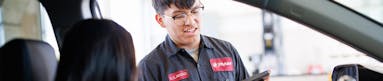 Jiffy Lube employee checking customer in for a fuel filter replacement service