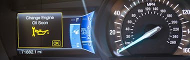 Change engine oil soon light illuminated on a vehicle's dashboard with a speedometer on the side
