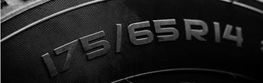 Close up on a new tire showing the tire size, aspect ratio, and wheel size