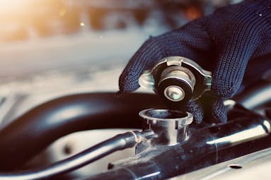 Jiffy Lube technician taking the cap off of radiator fluid