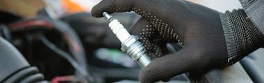 Close up of a technician holding a spark plug