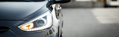 A close up of a vehicle's front headlight and blinker