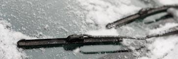 Winter windshield wipers covered in a thin layer of snow